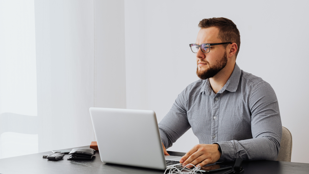 Business professional reviewing tax updates and regulatory information on a laptop in a modern office.